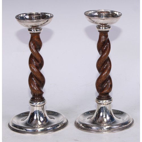 129 - A pair of Arts and Crafts silver and oak barley twist candlesticks, deep drip pans, dished bases wit... 