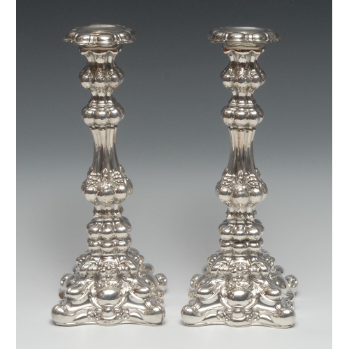 131 - A pair of Austrian silver fluted square table candlesticks, profusely chased with fruiting vine, 29c... 