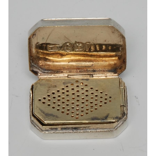 75 - A George III silver canted rectangular vinaigrette, hinged cover enclosing a pierced grille, gilt in... 