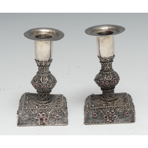 127 - A pair of 19th century Continental silver candlesticks, the filigree pillars and bases decorated wit... 