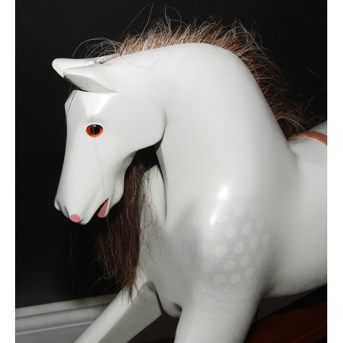 3235 - A 20th century rocking horse of small proportions on safety stand, the carved and later over-painted... 