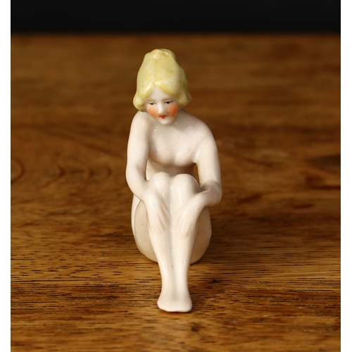 3295 - An early 20th century glazed china bathing beauty, coquettishly posed sitting with her hands on her ... 