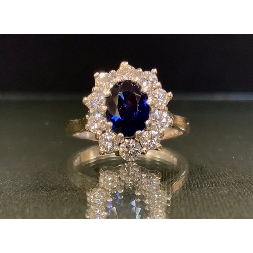 121 - A sapphire and diamond ring, central vibrant blue oval sapphire approx 7mm x 5.2mm x 4.06mm, calcula... 