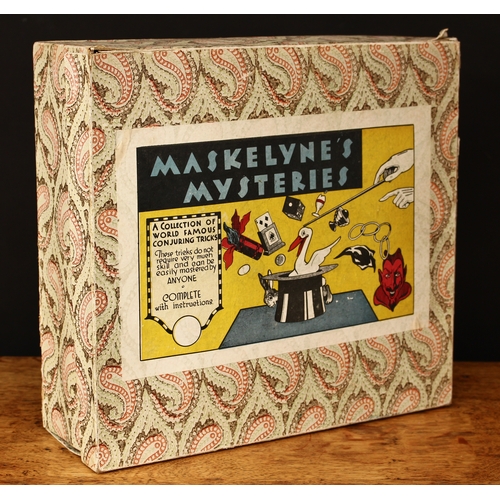 3334 - A 1950's Maskelyne's Mysteries box of conjuring tricks by Gamages, Holborn of London, comprising a t... 