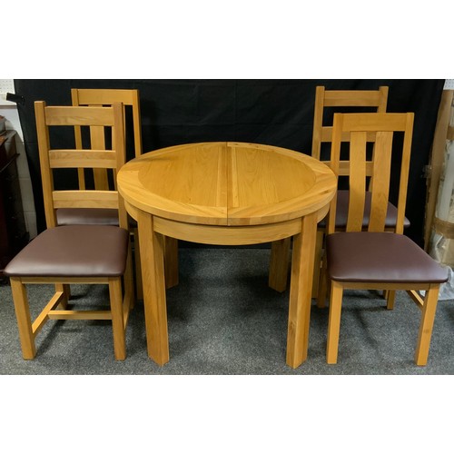 284 - An oak circular extending dining table with a set of four oak dinning chairs (5)