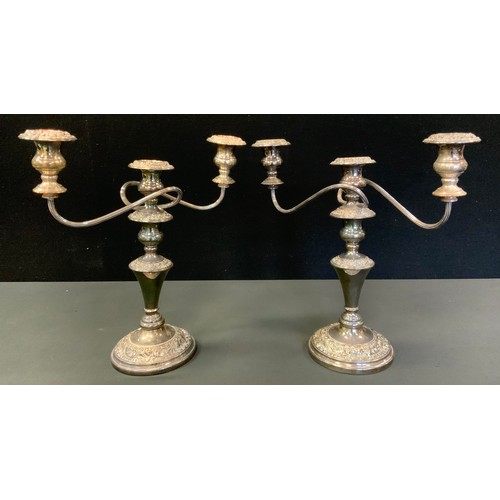 389 - A pair of plated three light two branch candelabra, cast with foliate scrolls, 35cm high