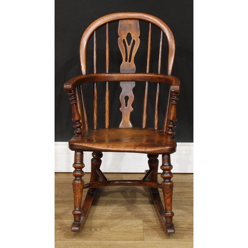 19 - A 19th century child’s Windsor rocking chair, 65.5cm high, 38cm wide, the seat 28cm wide and 23cm de... 