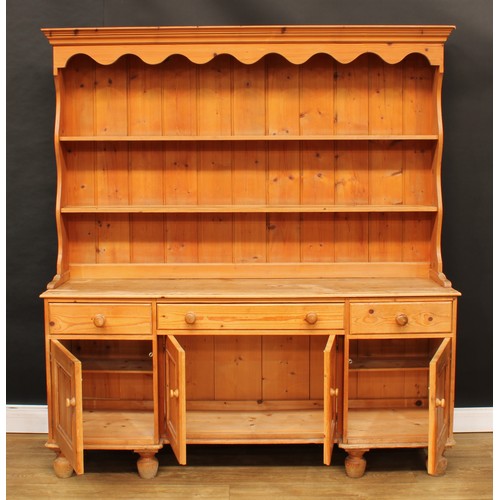 106 - A Victorian design farmhouse pine dresser, shaped apron above two shelves, the projecting base with ... 