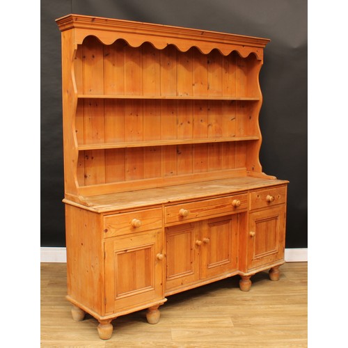 106 - A Victorian design farmhouse pine dresser, shaped apron above two shelves, the projecting base with ... 