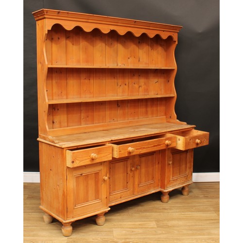 106 - A Victorian design farmhouse pine dresser, shaped apron above two shelves, the projecting base with ... 