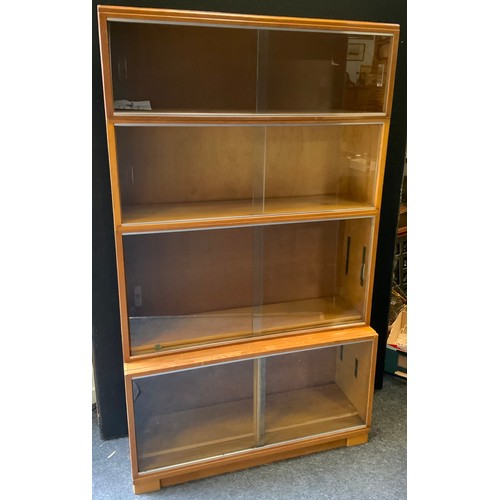 92 - A Golden oak Minty stackable bookcase, four sections, sliding glass doors