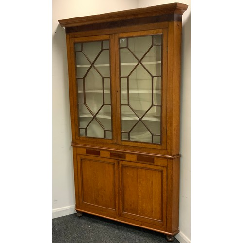 257 - A George III oak floorstanding corner cabinet, moulded cornice above two astragal glazed doors, the ... 