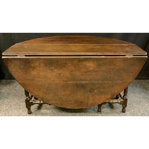 269 - An early 18th century oval oak drop leaf table, turned stretchers, 136cm wide, 144cm wide, c.1720