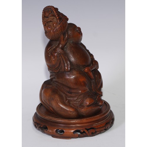 59 - A Chinese bamboo figure, carved as Budai holding a basket of flowers, 19.5cm high, pierced hardwood ... 