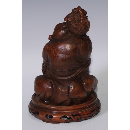 59 - A Chinese bamboo figure, carved as Budai holding a basket of flowers, 19.5cm high, pierced hardwood ... 