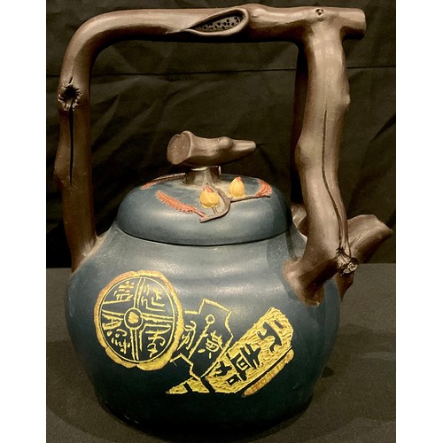 76 - A Chinese terracotta tea kettle, with naturalistic branch handle and spout, glazed in blue with scri... 