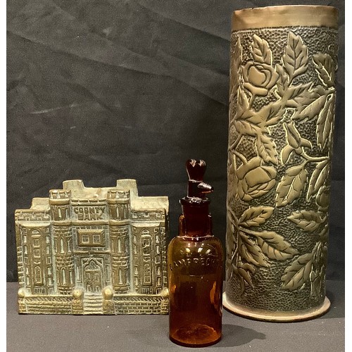 181 - A brass coin bank, County bank, 10cm high; a trench art brass shell case, dated '17; a glass bottle ... 