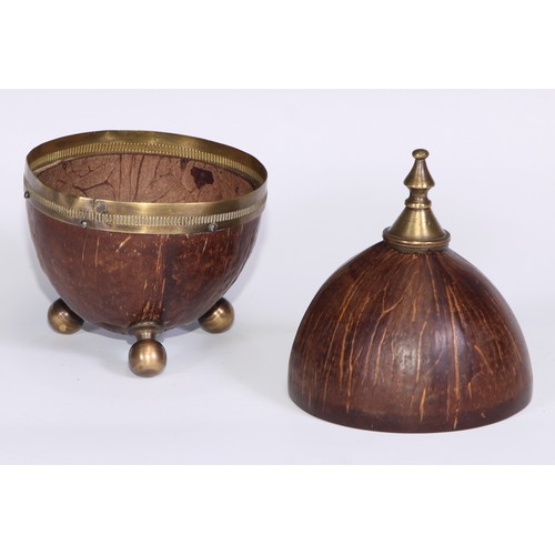 228 - An early 20th century coconut cup and cover, knop finial, bun feet, 18cm high