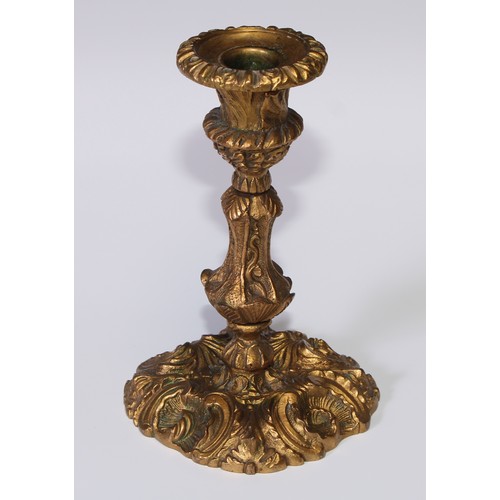 499 - A pair of Rococo ormolu candlesticks, cast with flowering C-scrolls, detachable nozzles, 17cm high, ... 