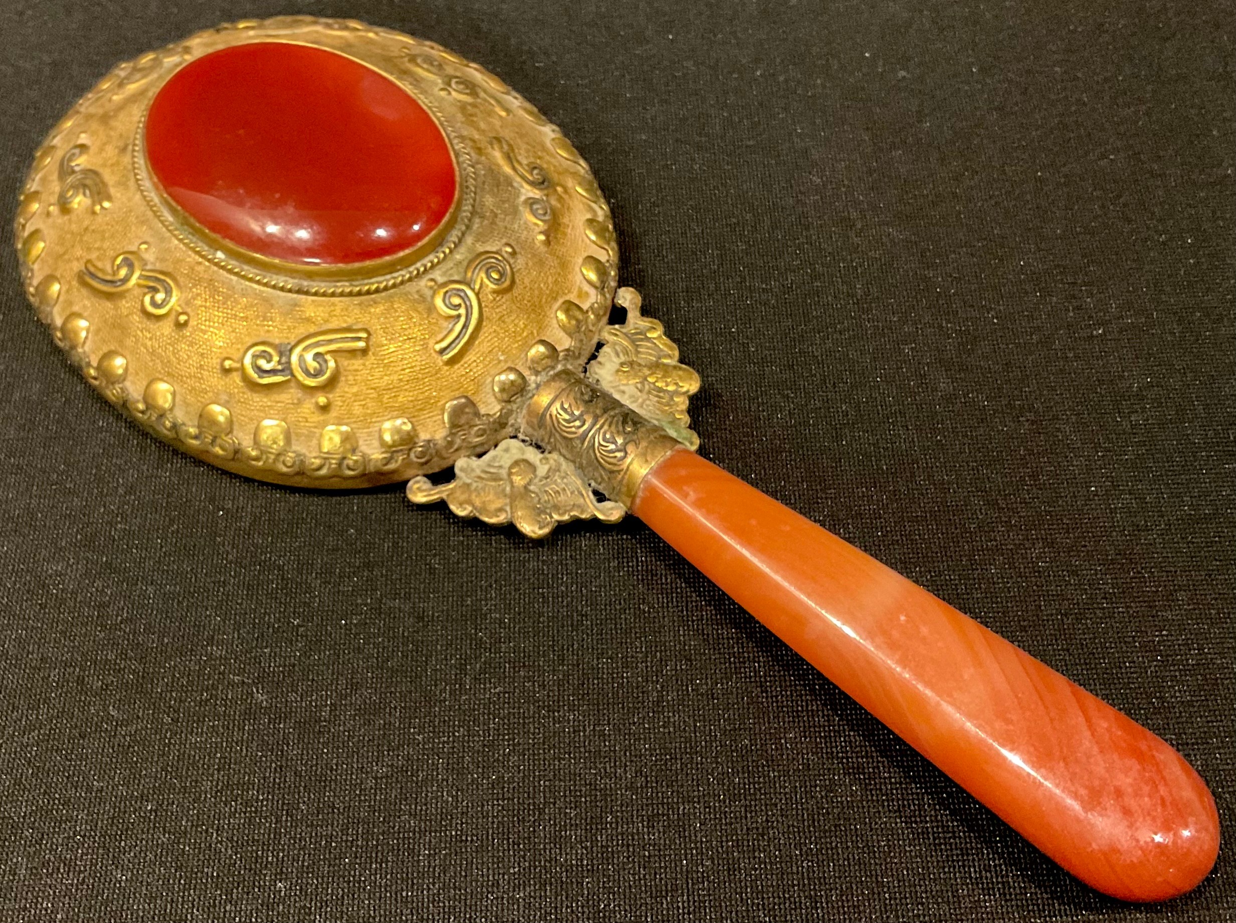 An ornate Chinese hand mirror, gilt set oval agate to verso,...