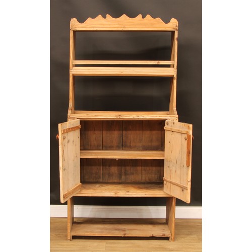 8 - A pine dresser, of narrow proportions, shaped pediment above a plate rack/shelf and a pair of doors ... 