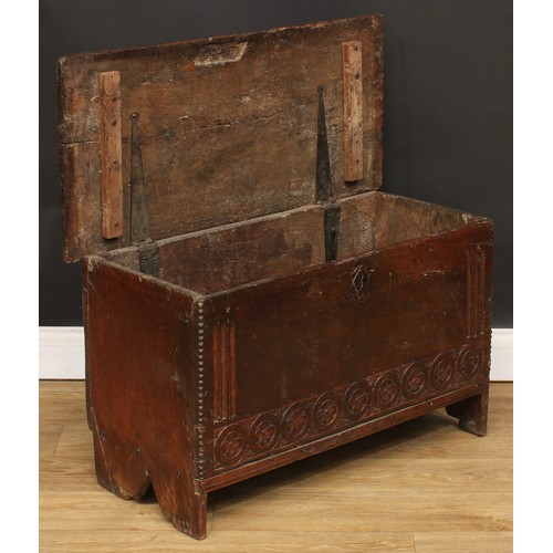 18 - A 17th century oak six-plank chest, hinged top with notched ends, the front panel carved with nullin... 