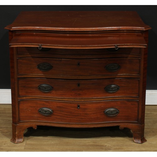 108 - A George III Revival mahogany serpentine bachelor’s chest, slightly oversailing top above a slide an... 