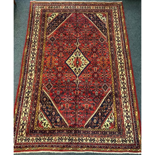 169 - A Persian Hamadan rug / carpet, the central diamond-shaped medallion within a densely woven field of... 