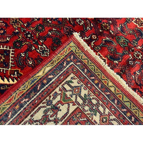 169 - A Persian Hamadan rug / carpet, the central diamond-shaped medallion within a densely woven field of... 