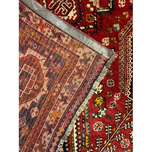 171 - A Persian Qashgai rug / carpet, triple medallion centre within a field woven with stylised flowers i... 