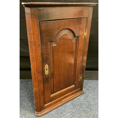 216 - An 18th century oak corner cupboard, c.1790

moulded cornice above arched field panelled door, H hin... 