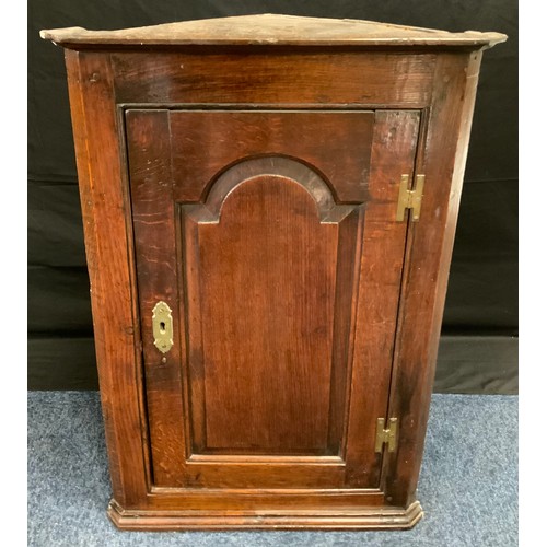 216 - An 18th century oak corner cupboard, c.1790

moulded cornice above arched field panelled door, H hin... 