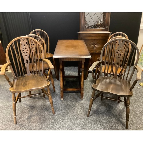 222 - A set of six wheel back dining chairs; a drop leaf table; a Jaycee corner cabinet (8)