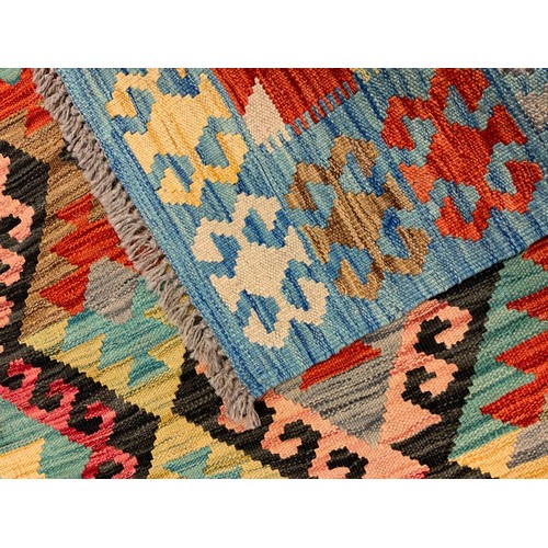 226 - An Anatolian Kilim rug / carpet, woven with geometrical motifs in shades of red, ochre, turquoise an... 