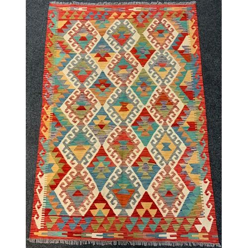 237 - An Anatolian Kilim rug / carpet, woven with an arrangement of diamonds within a field of red, turquo... 