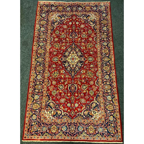 290 - A Kashan rug / carpet, the intricately woven central medallion in shades of indigo and cream within ... 