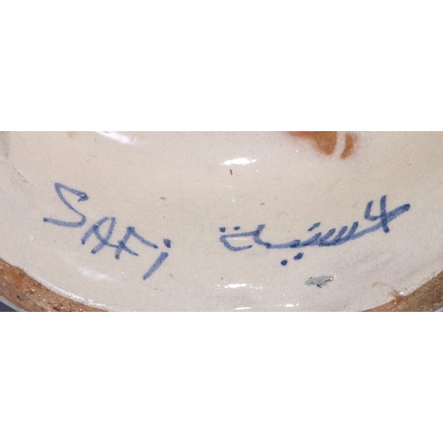 55 - An Islamic tin glazed earthenware candlestick, signed Safi and inscribed in Arabic, 15cm high