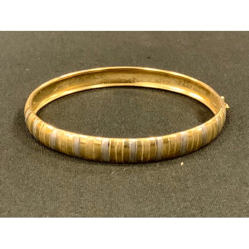 427 - A 9ct gold two tone textured bangle, 6.1g