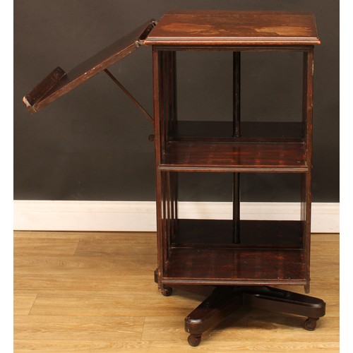 9 - An early 20th century oak revolving bookcase, one side with an adjustable reading ledge, 92cm high, ... 