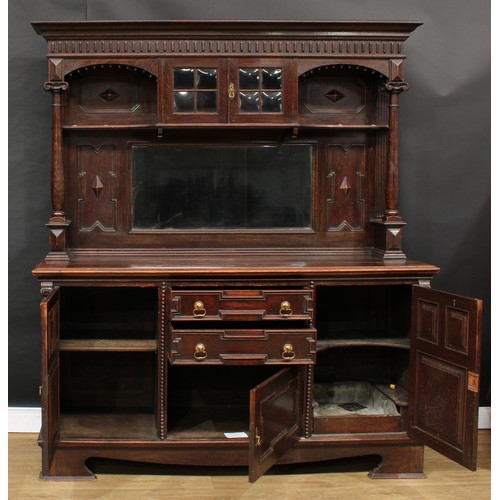 655 - A Jacobean Revival oak sideboard, outswept cornice above a pair of doors and a bevelled rectangular ... 