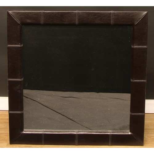 663 - Interior Design - a large faux brown leather wall mirror, 99cm x 99cm overall; another, suede wall m... 