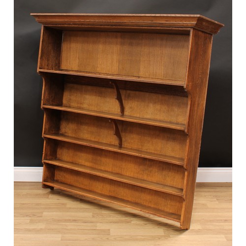 671 - An oak inverted waterfall wall shelf, moulded cornice above an arrangement of open bookcase shelves,... 