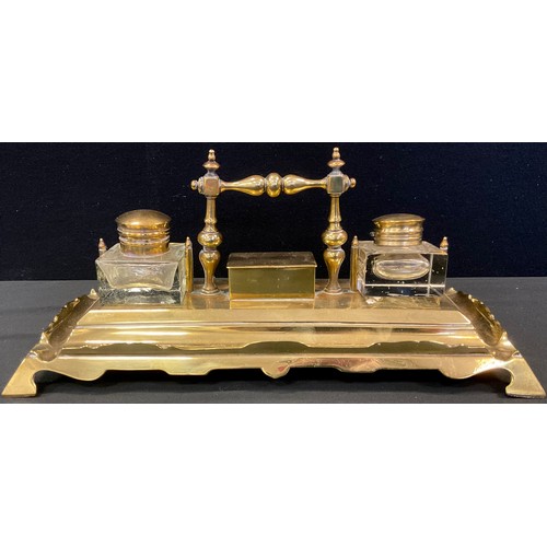 69 - An early 20th century brass standish, central stamp box, flanked by two clear glass wells, the recta... 