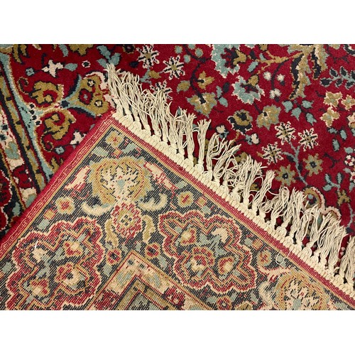 80 - A Middle Eastern woollen rug, with four medallions and leafy scrolls, on a red ground, 178cm x 260cm