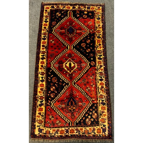 81 - A Persian Lori 'Nomad' rug / carpet, hand-knotted in deep tones of red, indigo and black, 217cm x 11... 