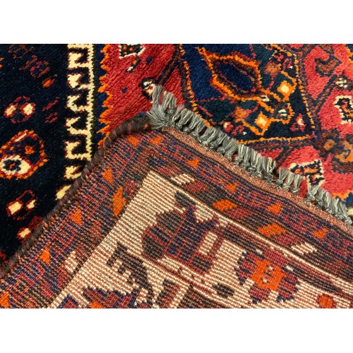 81 - A Persian Lori 'Nomad' rug / carpet, hand-knotted in deep tones of red, indigo and black, 217cm x 11... 