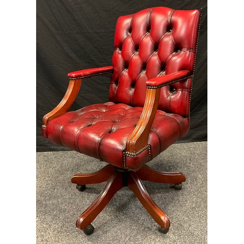 1 - A contemporary Gainsborough type desk chair, button back and seat, ox-blood leather, rise-fall and t... 