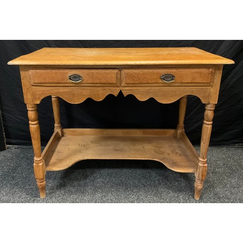 64 - A Victorian pine side table, rounded rectangular top above a pair of short drawers, shaped apron, tu... 