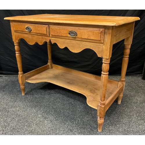 64 - A Victorian pine side table, rounded rectangular top above a pair of short drawers, shaped apron, tu... 