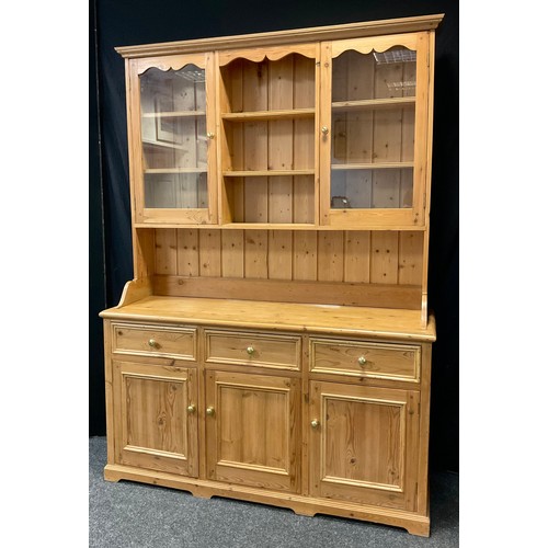 78 - A Pine Kitchen Dresser, the top section having a pair of glazed doors enclosing two tiers of shelvin... 